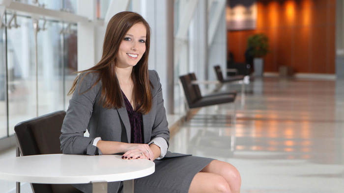 Person sitting in lobby in business attire.